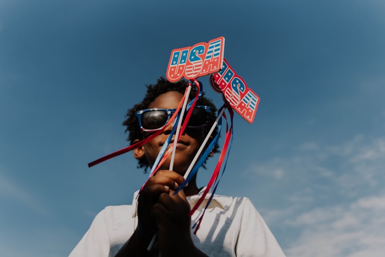 A child holds patriotic decorations upwards.