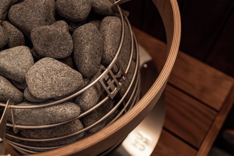 sauna, sauna stones, electric heater, nordic architecture, sauna design, dark wood, sauna inspiration, sauna lighting, black wall, modern sauna, interior, natural stone, heat, wood, steel, nordic design, luxury, heat therapy, relaxation, internal